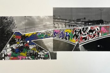  Black and white photo of a bridge with coloured graffiti 