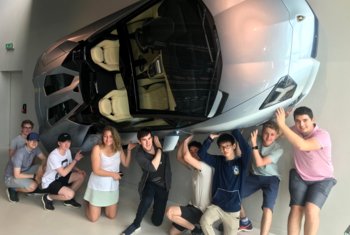  Pupils holding up a model of a car whilst on a trip 