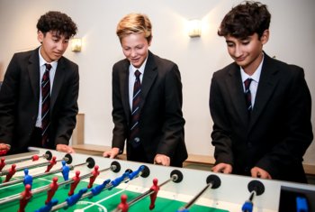  Boarders in Abraham House Common Room playing table football together 