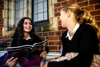  Pupils sitting in the New House study area and revising from an English Literature study guide together 