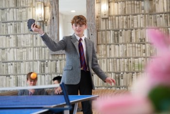  Pupil serving the ball over the net in a Table Tennis game in their Common Room 