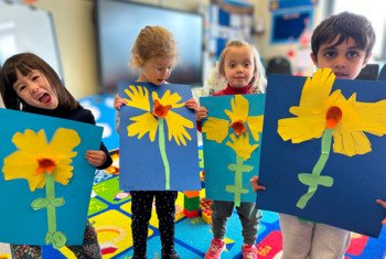  Pupils proudly holding their pictures of daffodils they created at Rockhoppers Holiday Club 