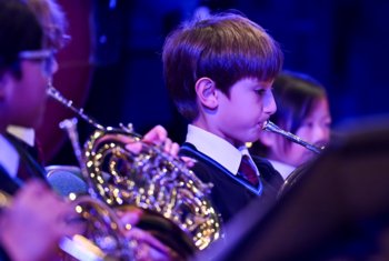  Prep School pupils playing brass instruments together in a concert in the Hall 