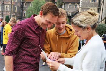  Pupil happily showing their parents their Results sheet on GCSE Results Day 