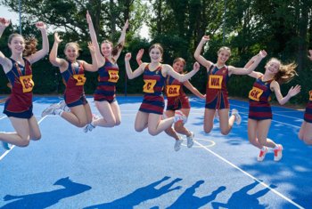  Netball players jumping for joy on the netball court 