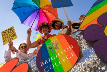  Pupils celebrating Brighton Pride by holding signs on the rainbow Brighton College float 