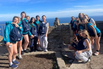  Pupils on Netball Tour in Gibraltar with a monkey with a view of the sea 