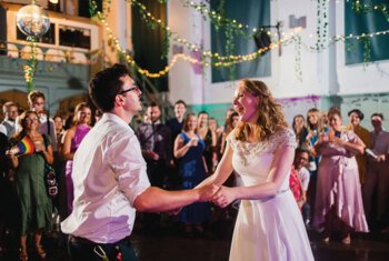  Newlyweds sharing their first dance in front of their family and friends 