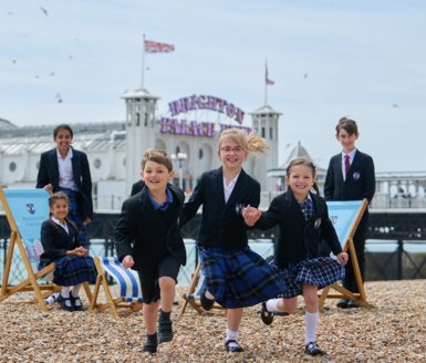  Pre-Prep pupils running along the stones on the beach in front of Brighton Pier 