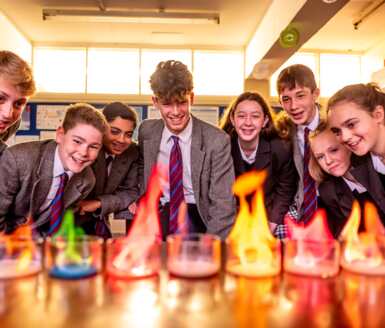  Pupils in a Chemistry lesson admiring different coloured flames as part of an experiment 