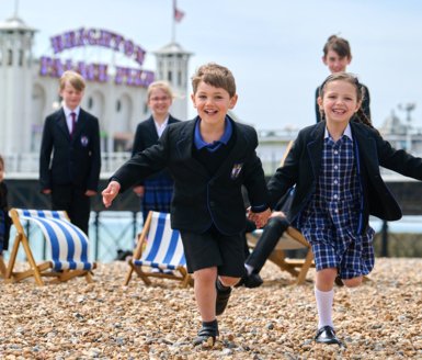  Pre-Prep and Prep School pupils enjoying being on the beach in front of Brighton Pier 