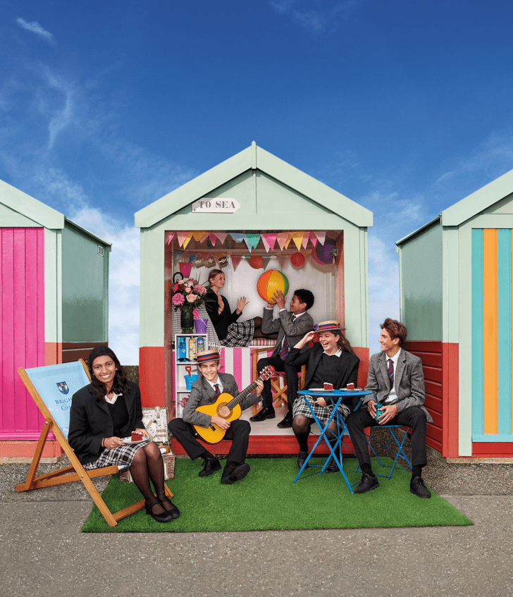  Pupils enjoying playing in a beach hut with a beach ball and a guitar 