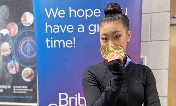  Dinburgh holding two gold medals at the British Open Gymnastics competition 