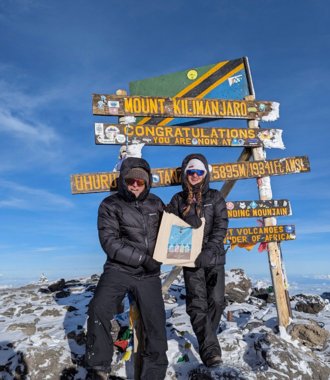  Ettiene at the top of Mount Kilimanjaro with a Brighton College tote bag raising money for charity 