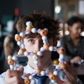 A-Level pupil examining a model of a molecular structure in a Chemistry lesson