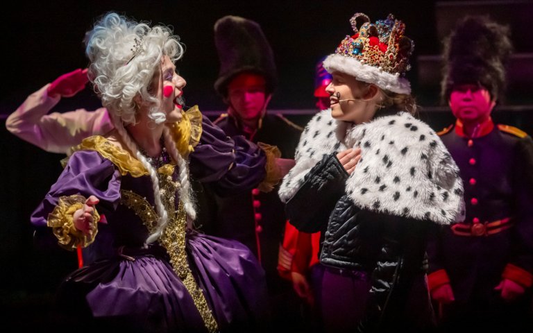  Prep School pupils dressed as a King and Queen on stage performing a play 