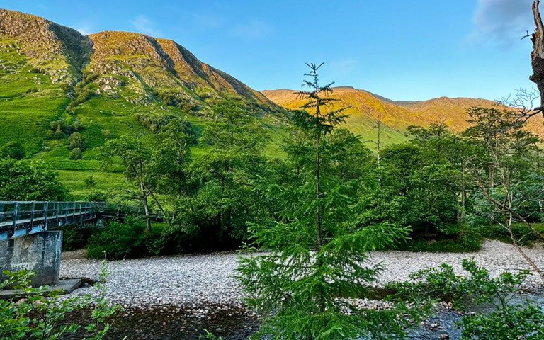  View of mountains and a river on a sunny morning whilst completing the Three Peaks Challenge 