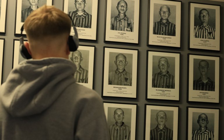  Pupil on a school trip to Auschwitz-Birkenau examining photographs of those who were imprisoned there 