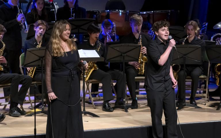  Singers in front of the microphones performing with the Swing Band at the Film Concert on stage 