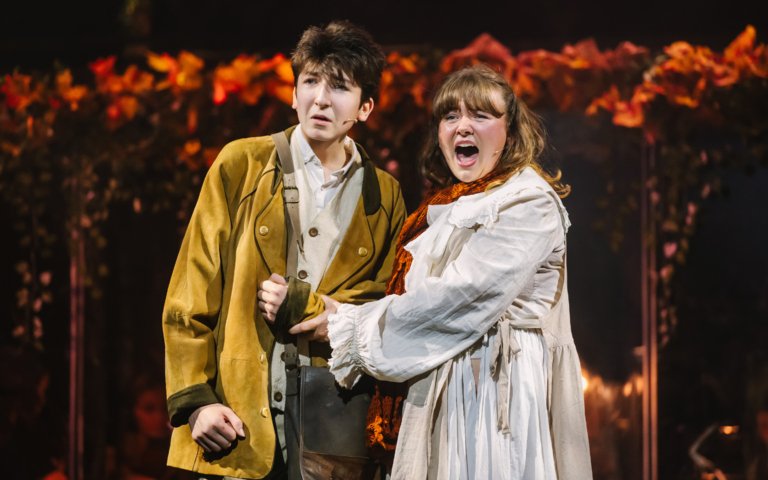  Pupils in the production of Into the Woods performing a scene on stage 