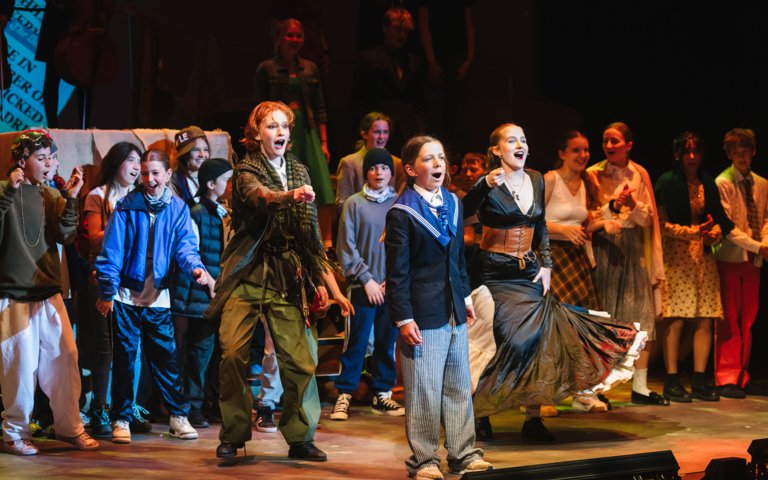  Cast of Oliver performing a musical number on stage 