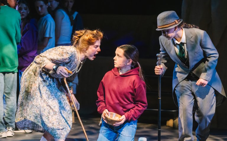  Lower School pupils performing a tense scene in their production of Oliver 