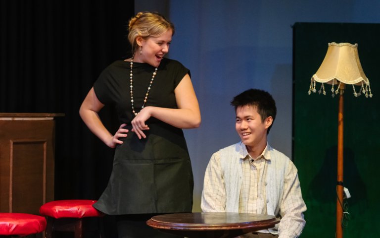  Pupils pretending to be waitress and a customer acting in the production of Two 