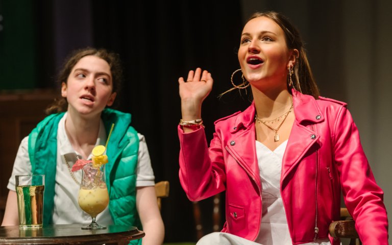  Lower Sixth pupils sitting together at a table with drinks in their production of Two 