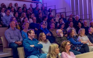 Parents sitting in the audience enjoying a performance in the Sarah Abraham Recital Hall