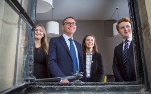 Richard Cairns and Sixth Form pupils looking out of a window