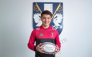 Rugby player Marcus Smith in Harlequins kit holding a Brighton College rugby ball