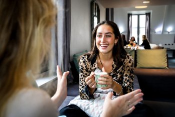 Pupils enjoying chatting in their Common Room on the sofas with a cup of tea