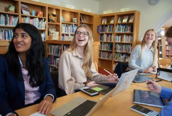 Pupils enjoying revising together sitting at a table in the Library