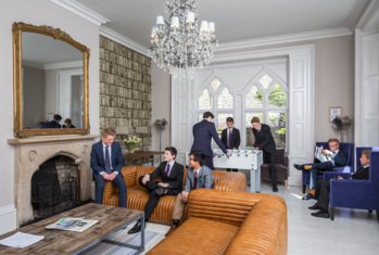 Head's House boarders playing table football, chatting and reading the newspaper in their Common Room