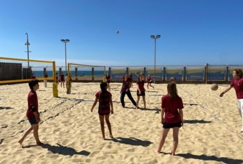 Pupils in games kit enjoying Volleyball together at Yellowave on Brighton Beach