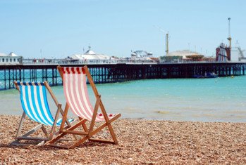 Deck Chairs on Brighton Beach with a view of the Pier and the sea