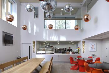 Tables and chairs inside the Simon Smith Café with disco balls hanging from the ceiling