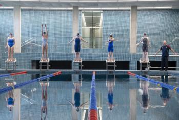 Pupils warming up and preparing to dive standing on the block in their lanes in the Lido in the SSS