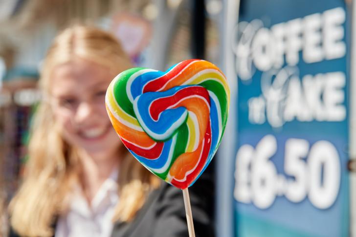  Smiling pupil holding a rainbow heart lollipop on the Pier 