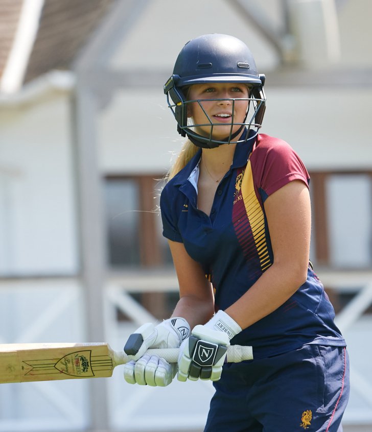  Pupil with cricket helmet and cricket bat getting ready to hit a ball on the Home Ground 