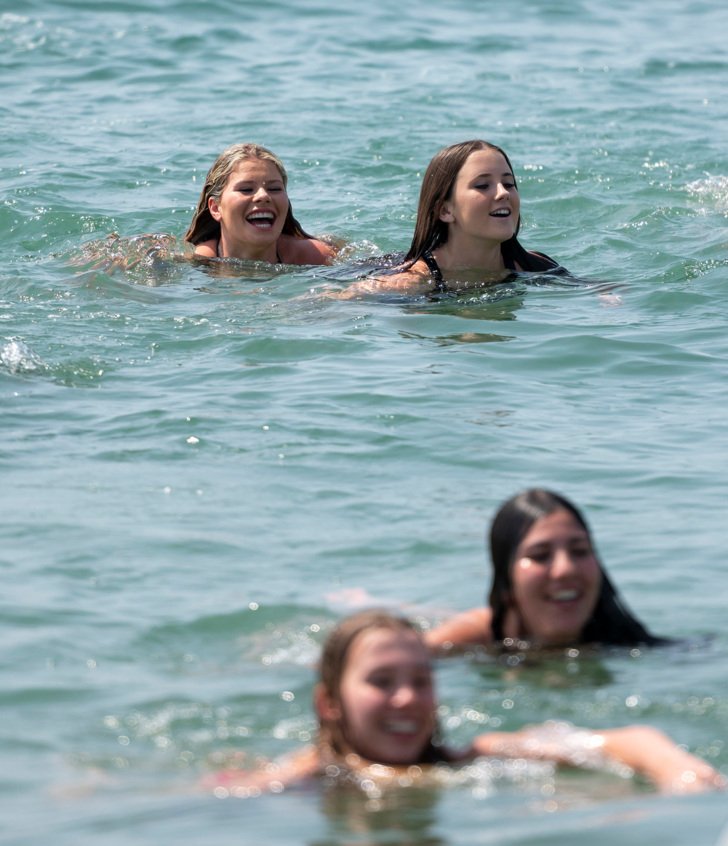  A group of pupils having fun swimming in the sea together 