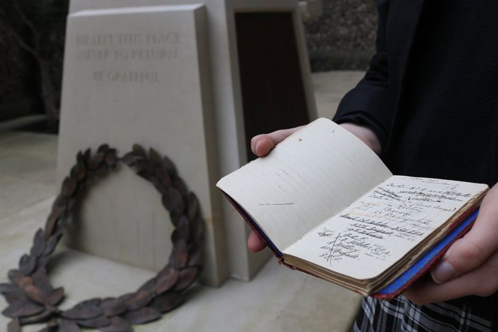  Pupil with an archive journal by the War Memorial outside the Chapel 