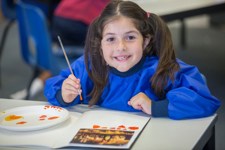  Prep School pupil in overalls painting in a lesson in the Art Room 