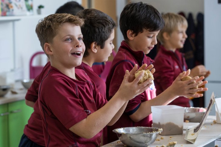  Pupils rolling dough between their hands and enjoying baking 