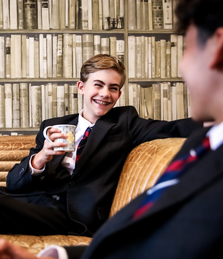  Boarding pupils sitting in their Common Room talking to each other whilst drinking a cup of tea 