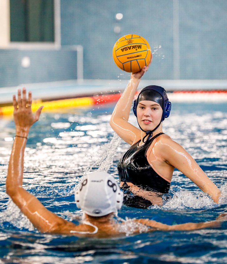  Pupil holding a Waterpolo ball preparing to shoot whist being defended 