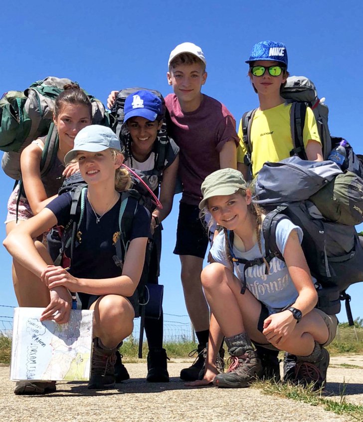  Pupils with all their camping gear and a map on a hike as part of their Silver DofE award 