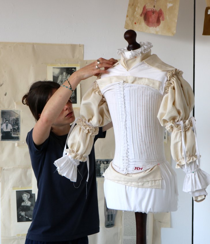  Pupil putting fabric and pins onto a mannequin to create a garment 