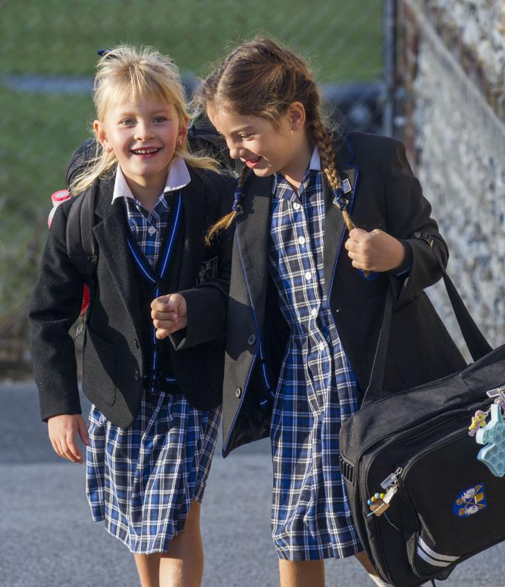  Pre-Prep pupils walking into school in the morning with their school bags in uniform 