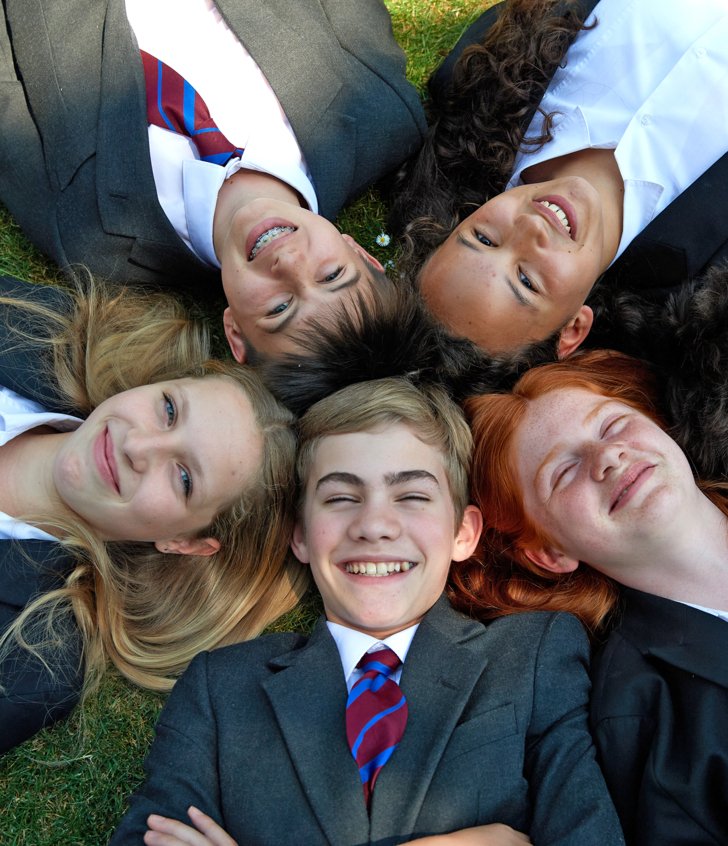  Pupils lying on the grass in a circle 